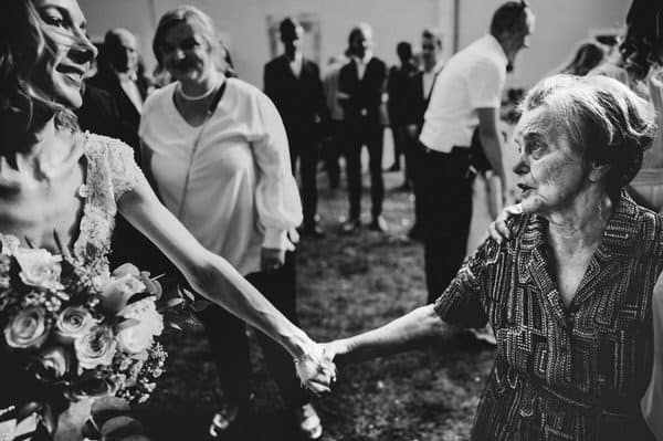 grandmother is holding her granddaughter hand and congratulate to her for being married in a emotional way
