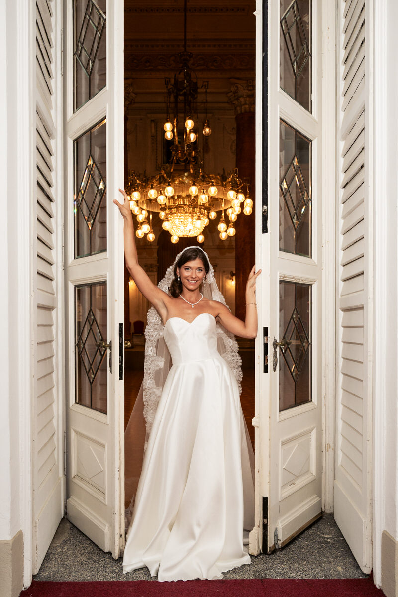 Bride posing under a chandelier in an elegant doorway